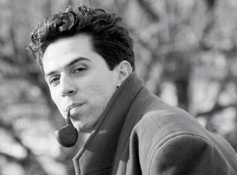 Photo en noir et blanc de François W. Beydoun, portant un manteau croisé et une pipe, dans les années 90.